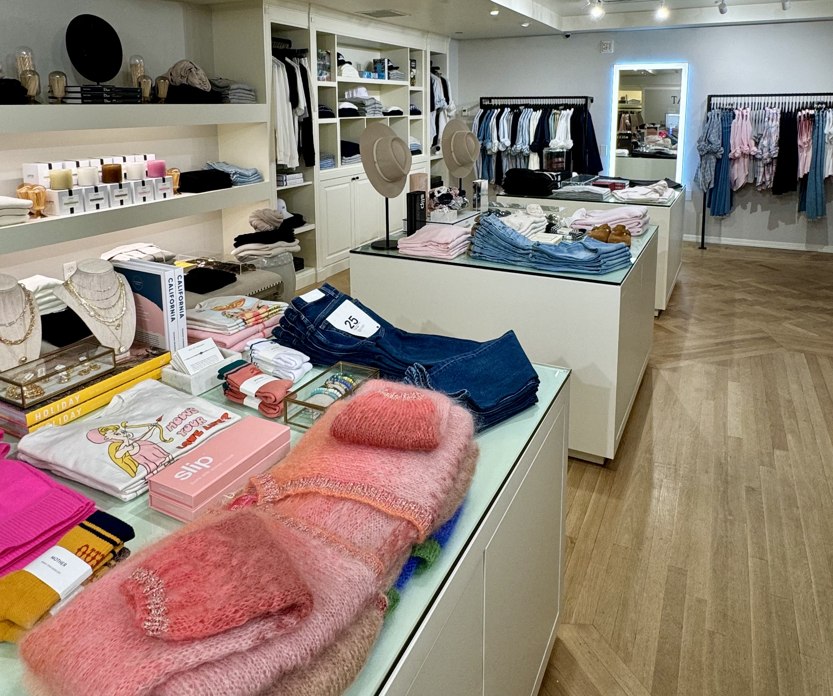 Completed Casa Del Mar boutique with styled tables, apparel rails, accessories, and layered product stories