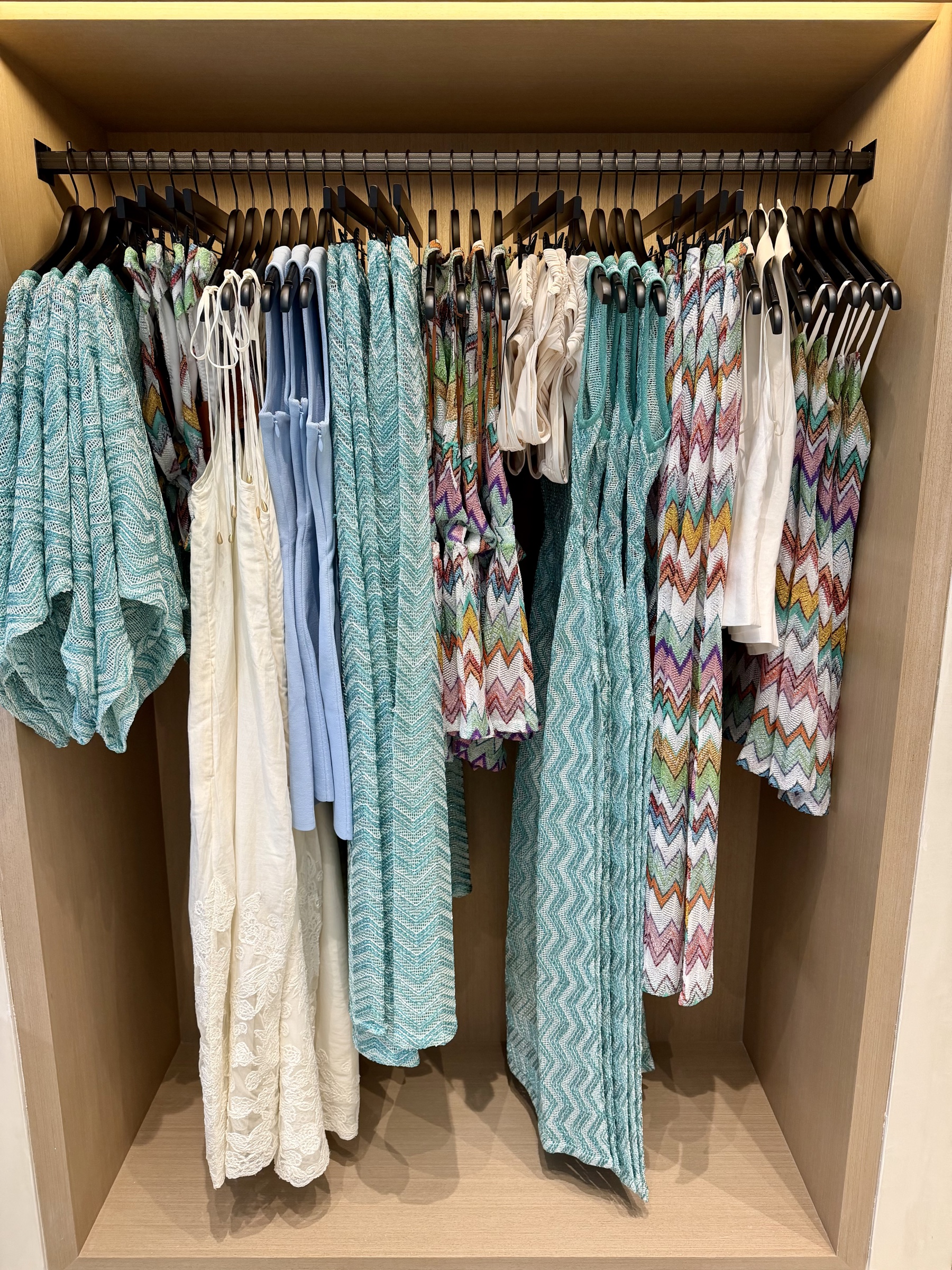 Completed Malibu apparel display with coordinated turquoise, white, and multicolor resort pieces