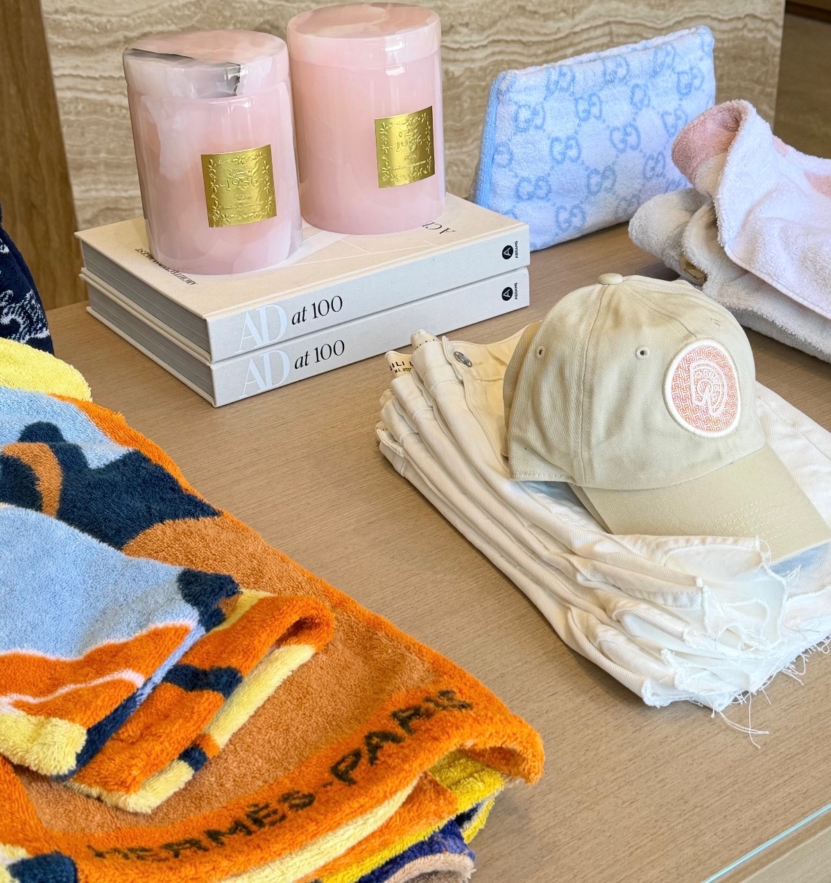 Pink candles, resort accessories, folded apparel, and books styled on a display table at The Shop by WHEAT in Malibu