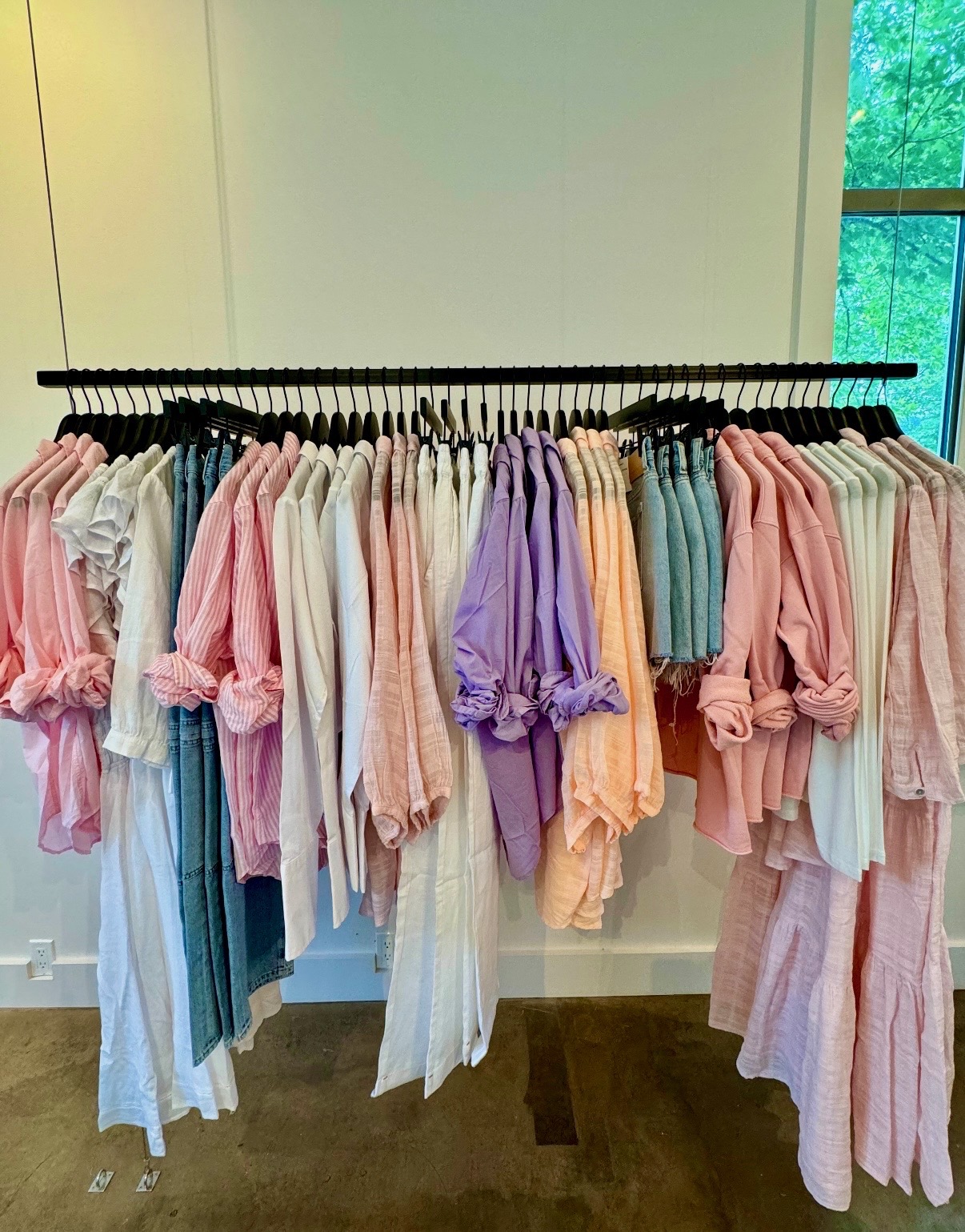 Pink, white, lavender, peach, and denim apparel arranged on a boutique rail at Solage in Napa Valley